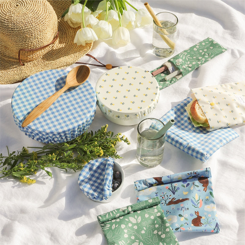 Esembly Home Goods in designs illustrated by Flora Waycott on a white linen sheet