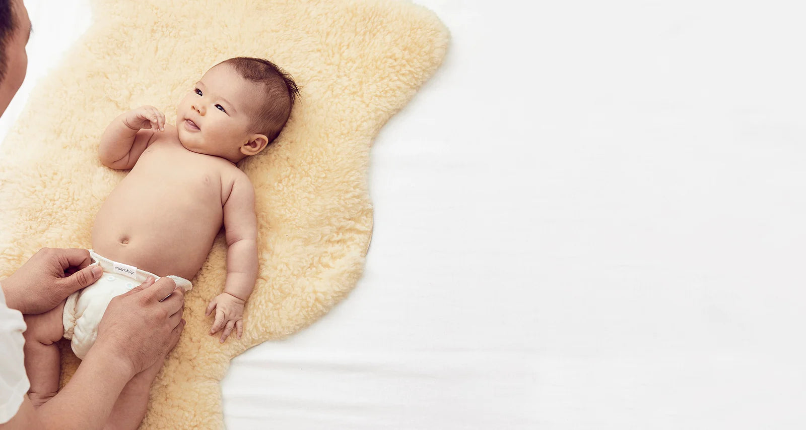 A baby being changed into an Esembly cloth diaper