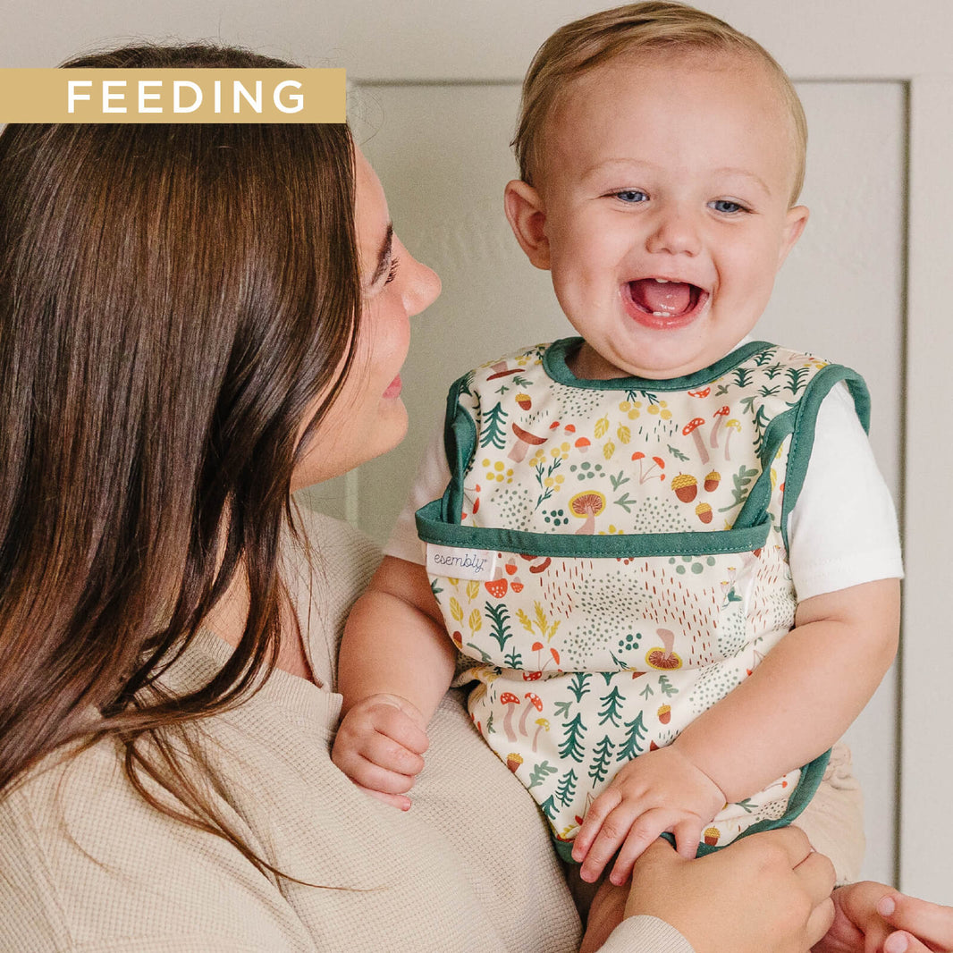 Baby in an Esembly Bib being held by their mom