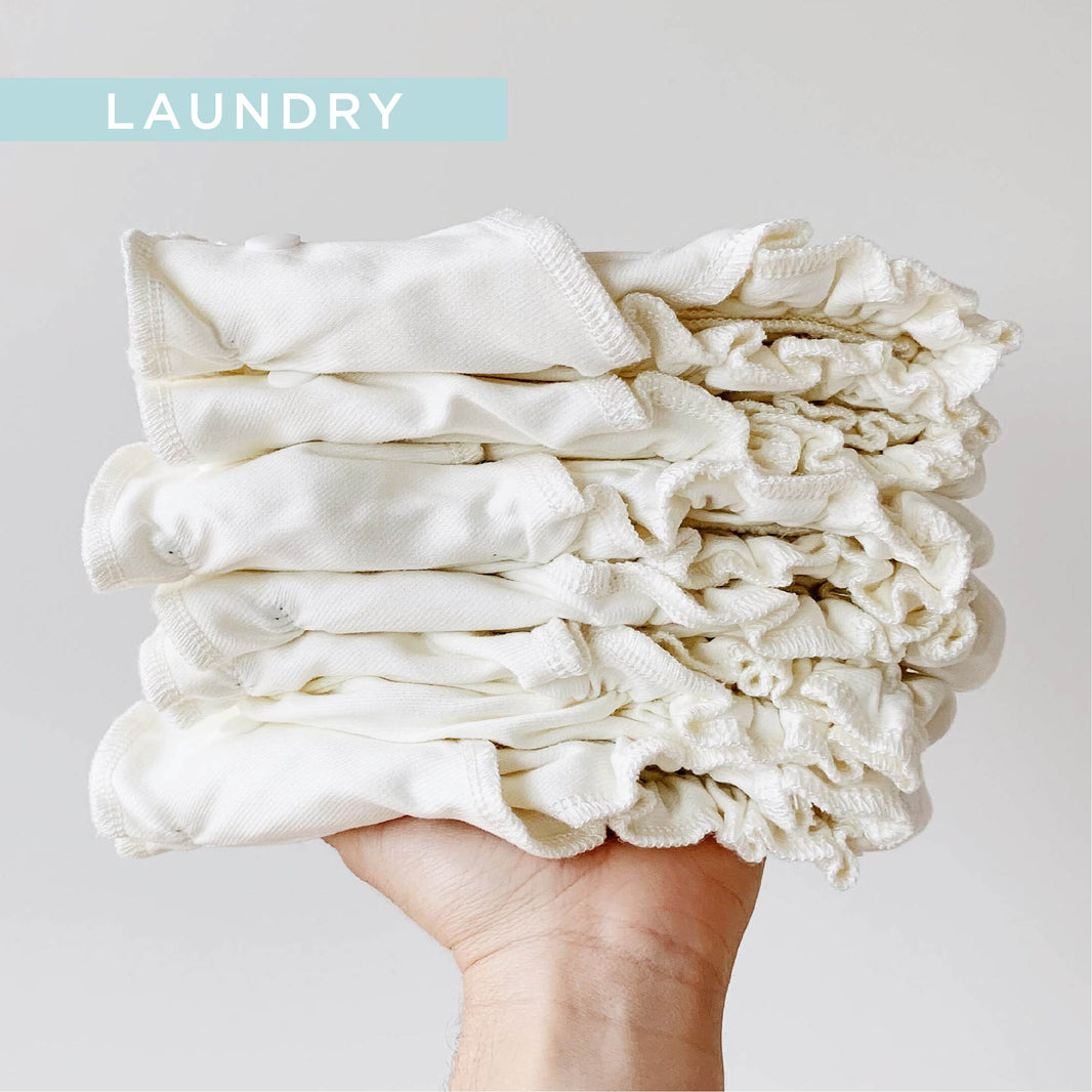 Hand holding stack of cloth diaper Inners