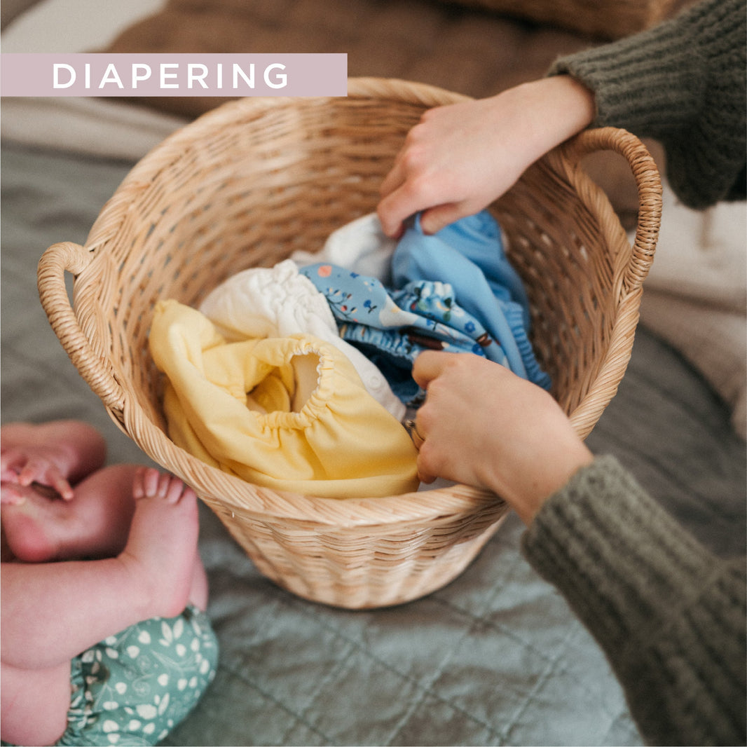 Woman reaching into laundry basket for cloth diapers