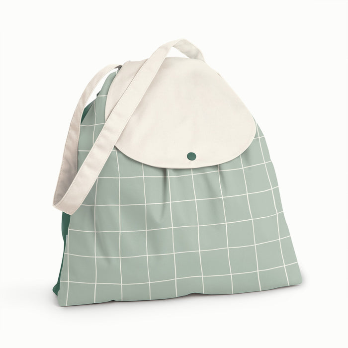 Front view of Esembly Day Bag with a cream flap, dark green back, and mid-tone green with an outlined check pattern