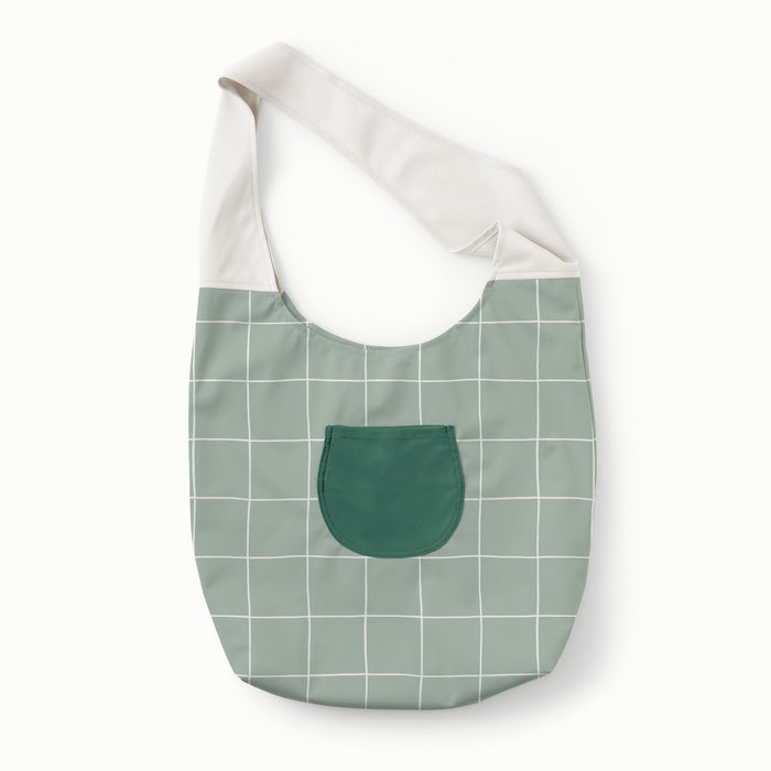 Front view of Esembly Carryall Bag in Lattice color way with a Lattice (a light green background with white lined grid pattern) body, dark green pocket, and an off-white strap