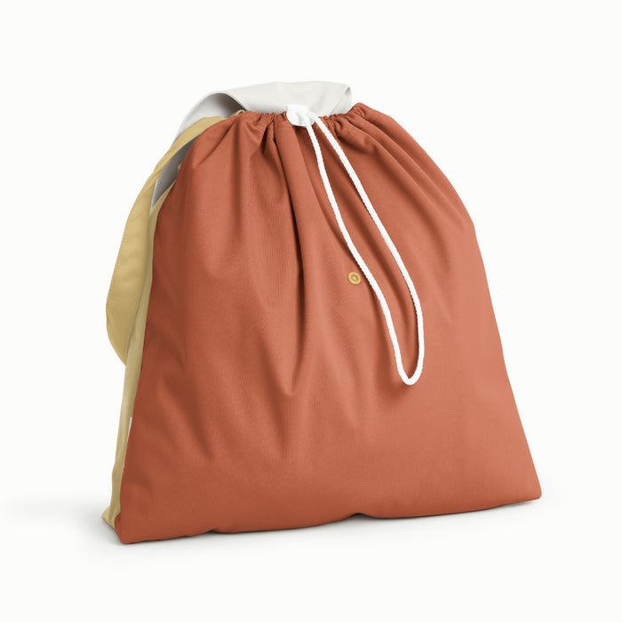 Front view of Esembly Day Bag a light green flap and back, a mid-tone green front, and a blush strap.