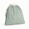Front view of Esembly Day Bag with a cream flap, dark green back, and mid-tone green with an outlined check pattern