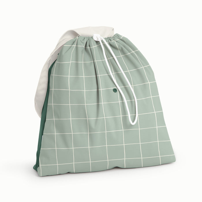 Front view of Esembly Day Bag with a cream flap, dark green back, and mid-tone green with an outlined check pattern