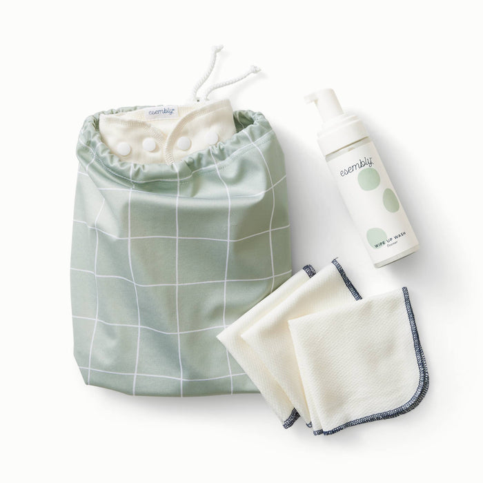 Front view of two waterproof bags with toggle close tops in light green with white lines  and three cloth wipes and a foamer bottle