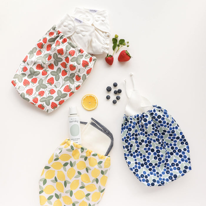 Set of reusable storage bags with fruit patterns on a white background