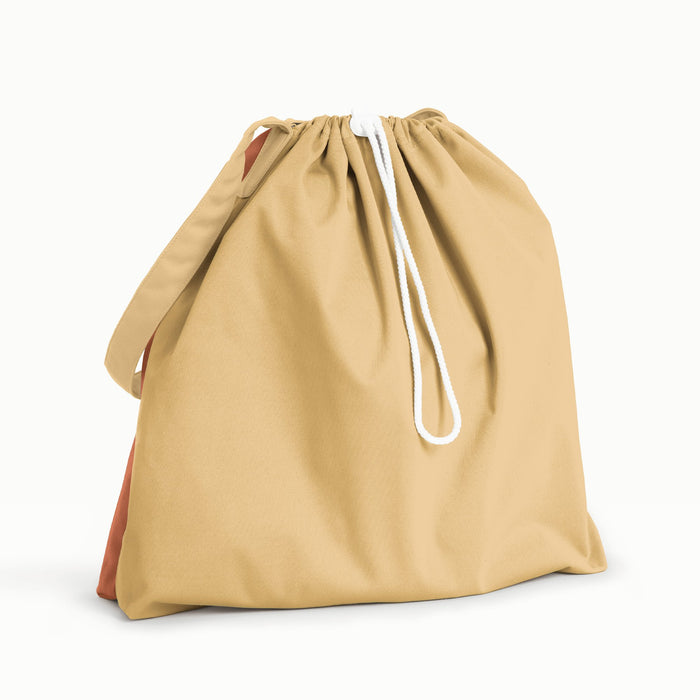 Back view of Esembly Day Bag a light green flap and back, a mid-tone green front, and a blush strap.