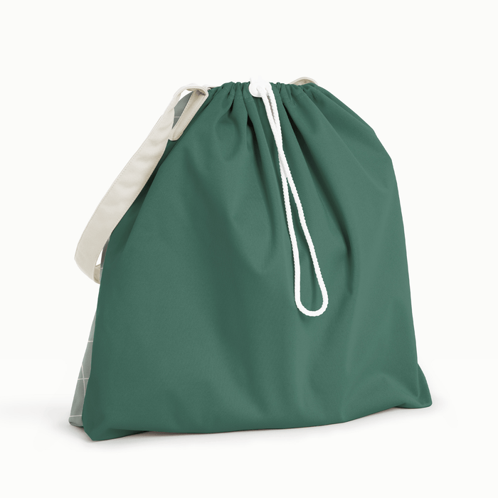 Back view of Esembly Day Bag with a cream flap, dark green back, and mid-tone green with an outlined check pattern