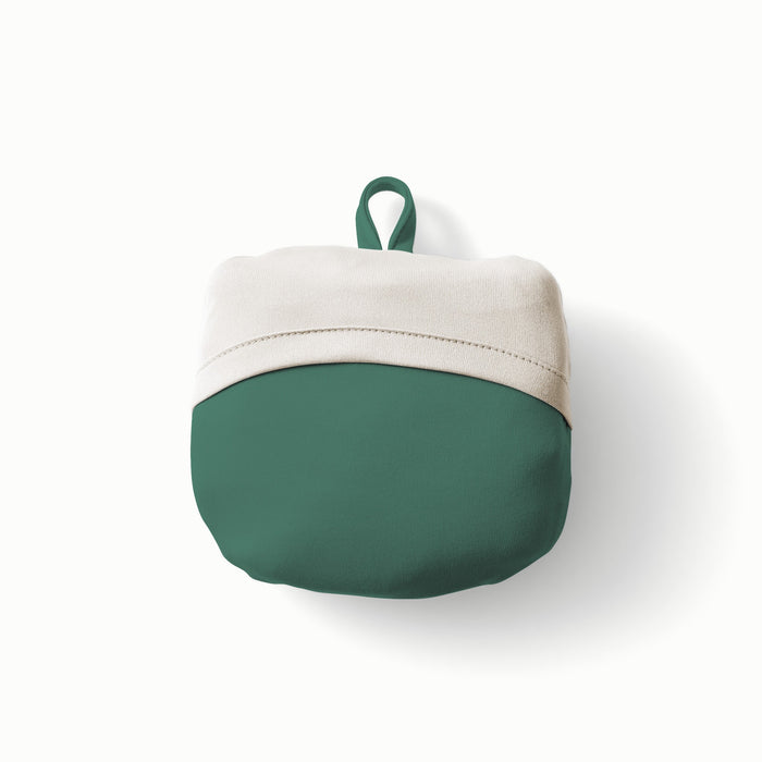 Rolled Up View of Esembly Carryall Bag n Lattice color way with a dark green exterior, off-white flap, and dark green loop at the top