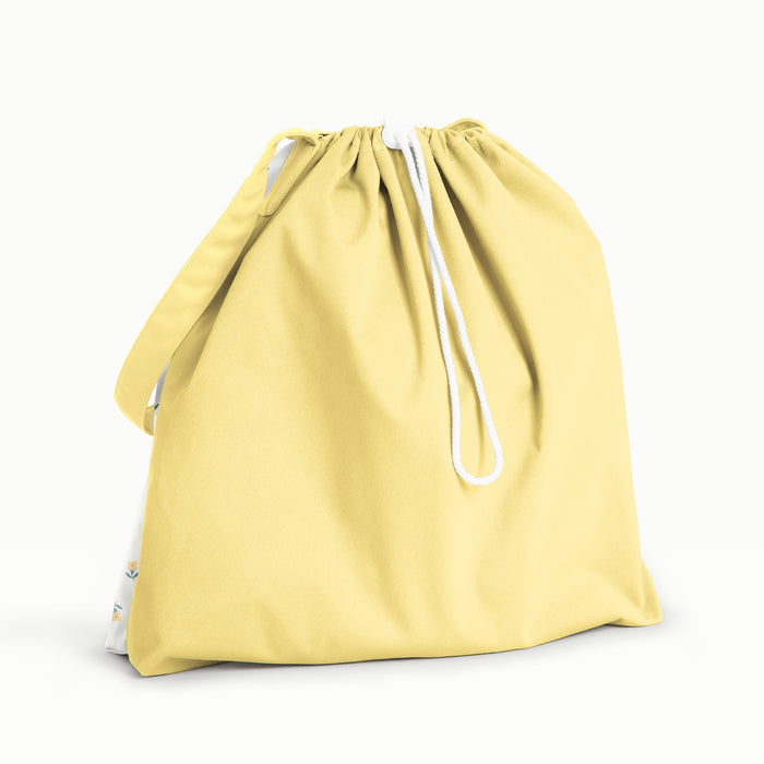 Back View of a Buds Day Bag - The back and strap are Buttercup (a buttery yellow solid color) and the front is Buds (a parchment background with tiny yellow and green flowers)