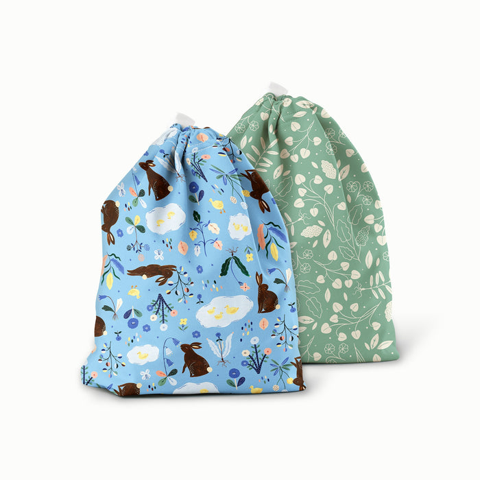 Bunnies (bunnies, flowers, and ducks illustrated by Flora Waycott on a mid-tone blue background) and Botany (green background with white leaves) ditty bags