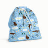 Front View of an Esembly Day Bag with Bunnies on the front (bunnies, flowers, and ducks illustrated by Flora Waycott on a mid-tone blue background), blue gingham on the flap and back, and a mid-tone blue strap