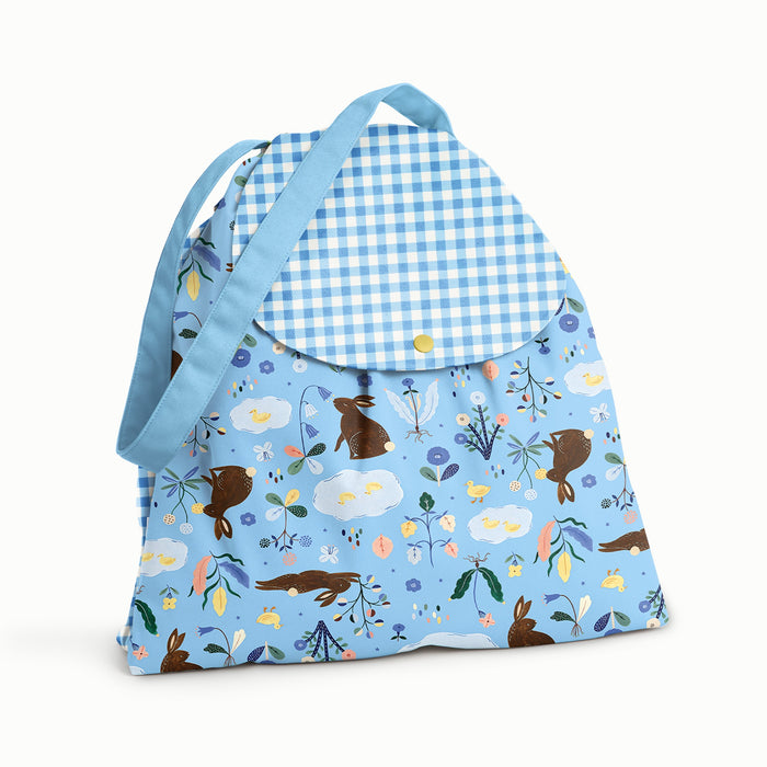 Front of the bag is in Bunnies (bunnies, flowers, and ducks illustrated by Flora Waycott on a mid-tone blue background) with the flap and bag in blue gingham, and the strap in a matching soft mid-tone blue.