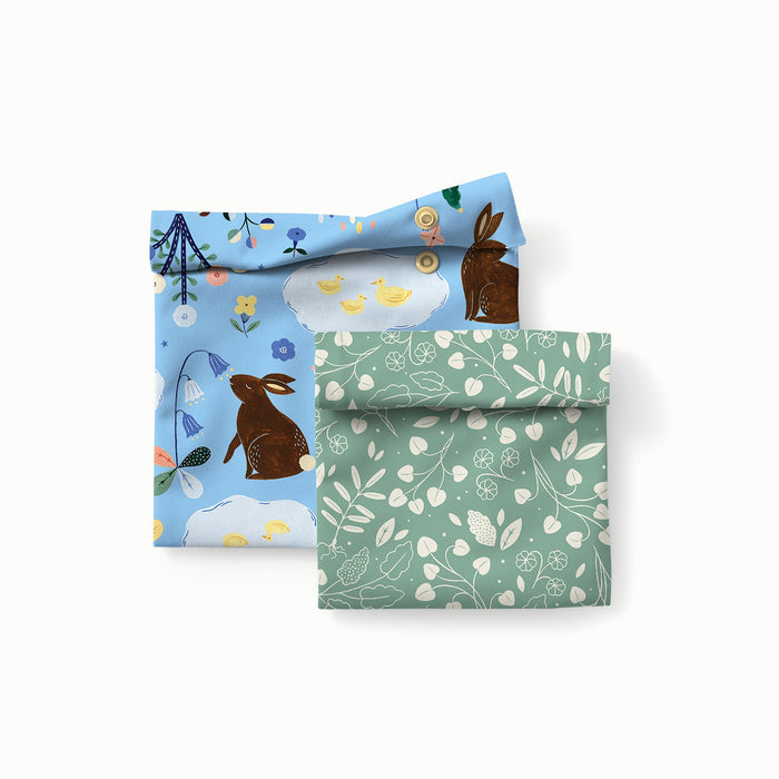 Bunnies (bunnies, flowers, and ducks illustrated by Flora Waycott on a mid-tone blue background) Sandwich Bag and a Botany Snack Bag (green background with white leaves)