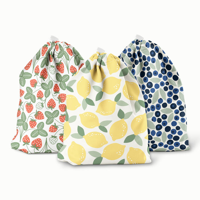 Three drawstring bags with fruit pattern designs on a white background