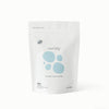 A white stand-up pouch of Esembly Enzyme Stain Buster, featuring light blue circular graphics and black text, photographed on a clean white background.