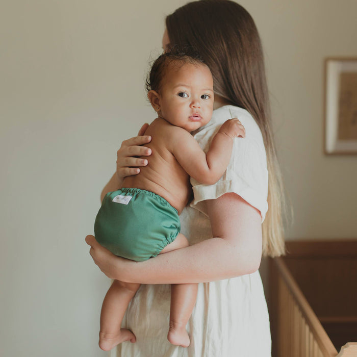 Mom holding baby wearing an Outer a deep dark green color