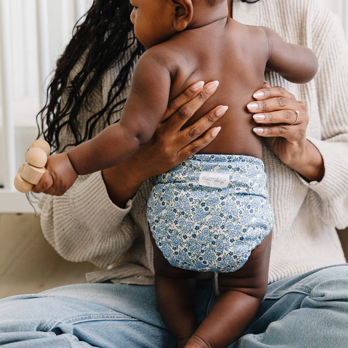 Woman holding a child wearing a floral Outer