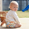 Baby sitting on the ground wearing an Esembly Outer in Funfetti