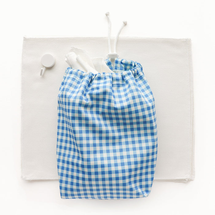 Blue Gingham Ditty Bag next to a stack of paperless towels and a white hook