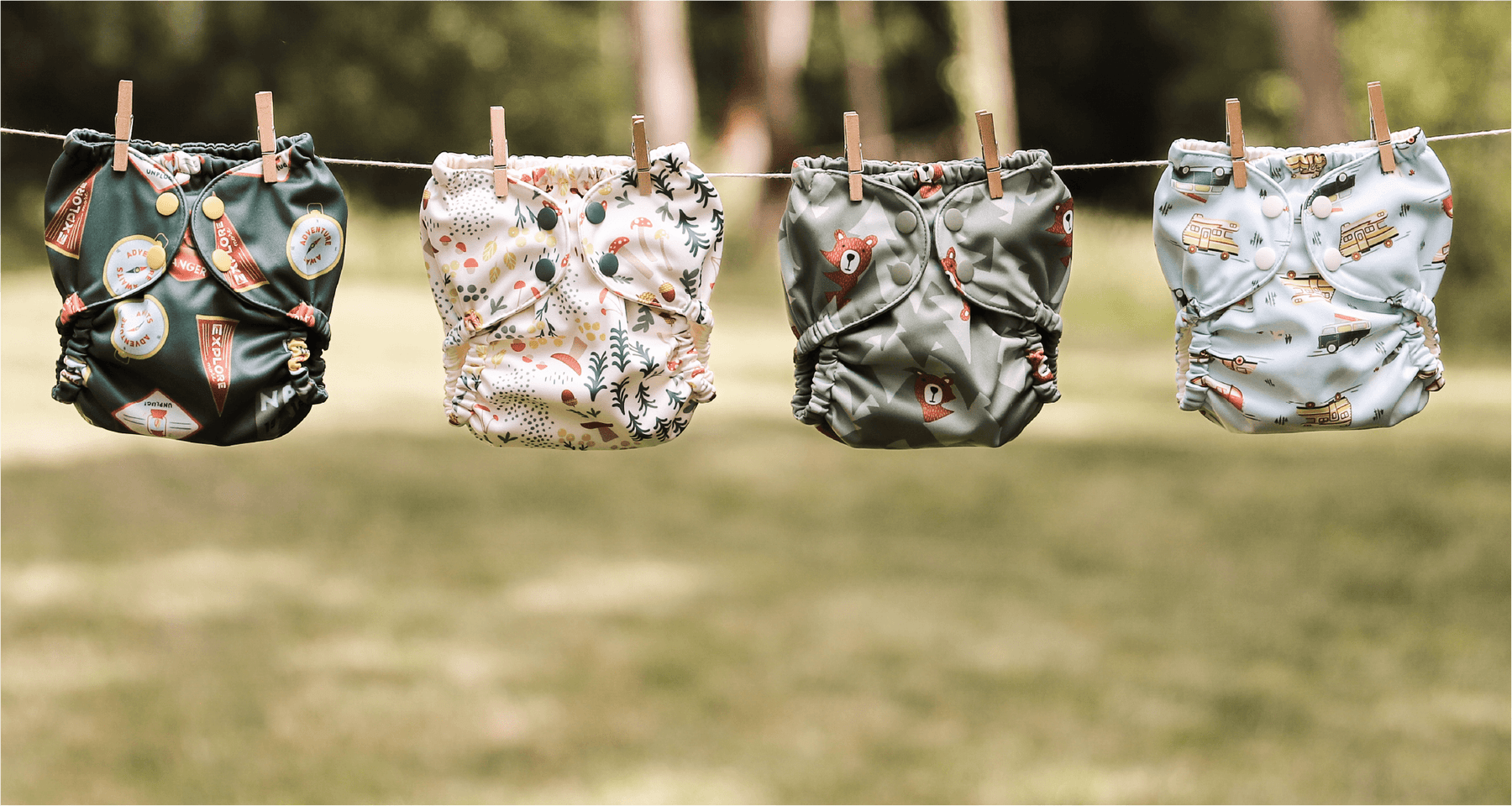 Four National Parks Esembly Outers hanging on a drying line in front of a forest