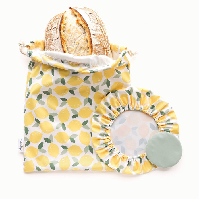 Reusable bread bag with lemon pattern containing bread, next bowl caps