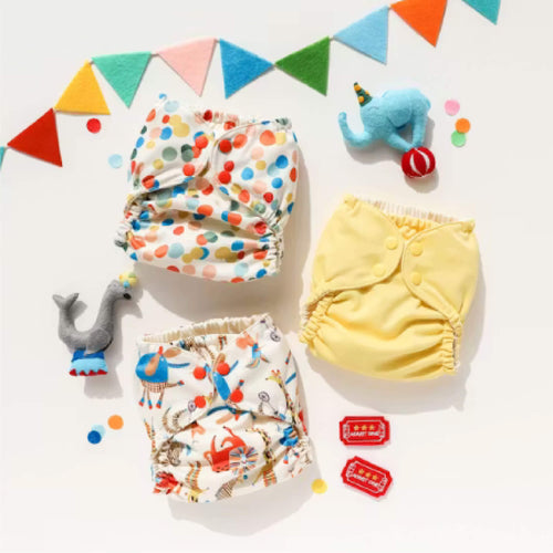 Three Esembly Outers designed by Jana Glatt next to colorful bunting and circus felt toys