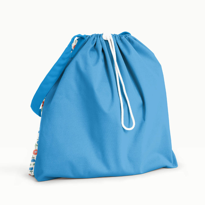 Day Bag in Poppies with a bright blue back, flap, and strap