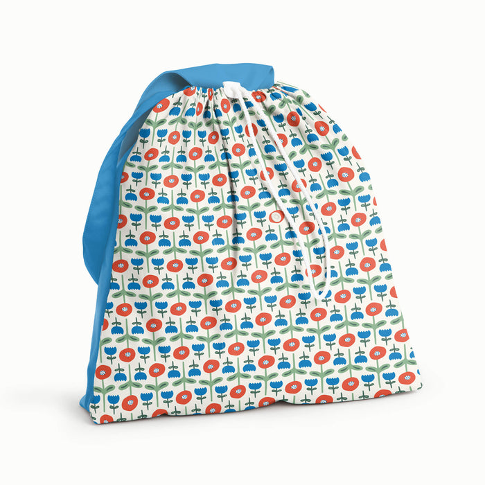 Day Bag in Poppies with a bright blue back, flap, and strap