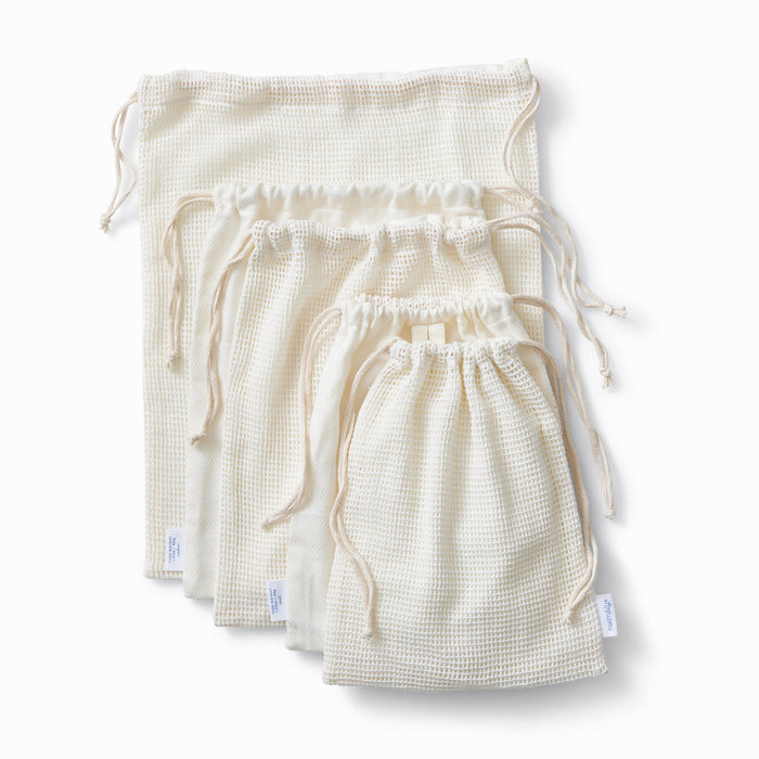 Top view of five produce saver bags of various sizes laying flat on a white background