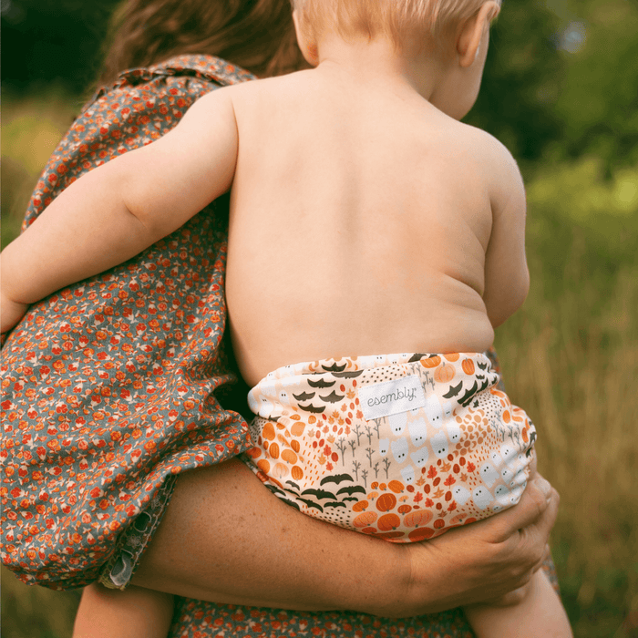 Child wearing a fall patterned cloth diaper outdoors