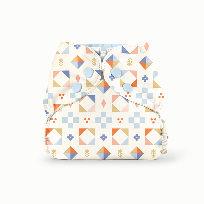 Colorful geometric diaper cover on a white background