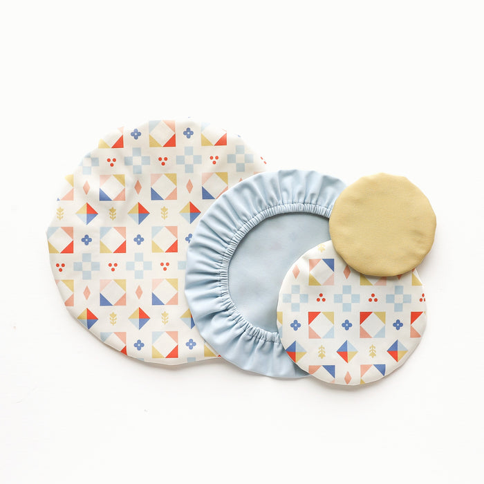 Four Bowl Caps. Two with geometric patterns, one in solid light blue, and one in solid light yellow on a white background