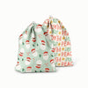 Ditty Bag in Santas (a mint green Outer with illustrated Santa heads, mistletoe, and candy canes) and Peace + Joy (a white background with red peace and green joy words)