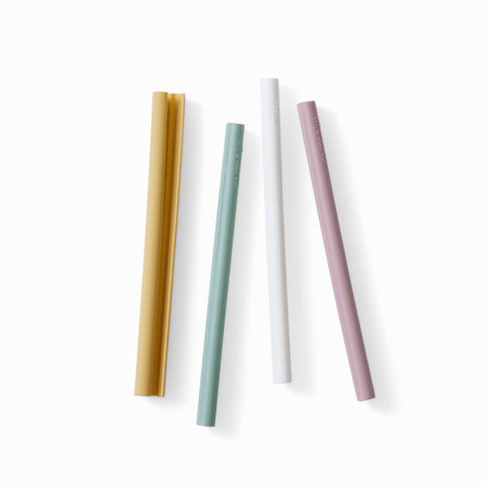 Four silicone straws that open for easy cleaning in muted yellow, light green, white, and light purple