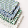 Stack of tea towels with various patterns on a white background