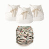 Three off-white reusable cloth diaper covers with fabric bows are shown above a single patterned reusable diaper. The patterned diaper has a multicolor design featuring green, red, black, and beige tractor and road elements on an off-white background.