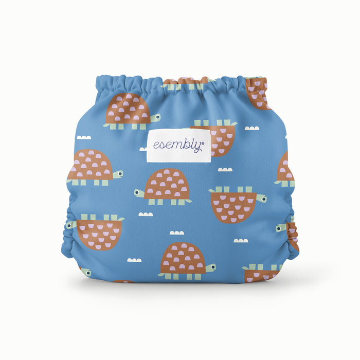 Blue diaper with turtle pattern and 'essembly' label on a white background