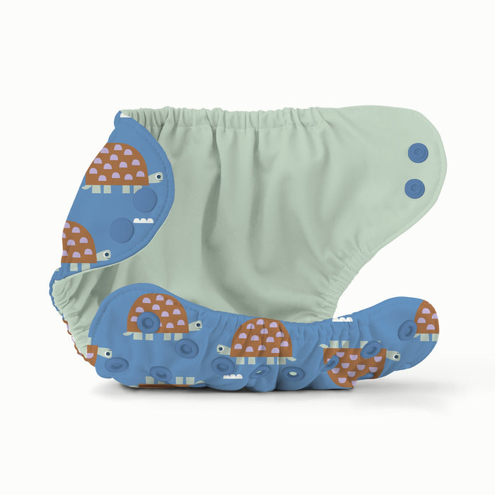 Children's swim diaper with turtle design on a blue background with a green interior
