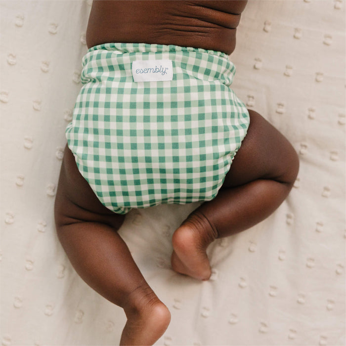 Green checkered diaper on a baby against a neutral background