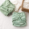 Solid Green and Green Gingham Outers stacked on an Inner next to a basket filled with Inners