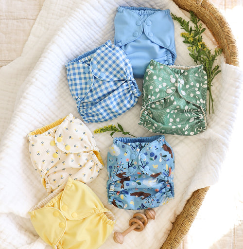 Esembly Outers in Gingham, Cornflower, Bunnies, Aloe, Blush, Buds, Buttercup, and Botany in a basket