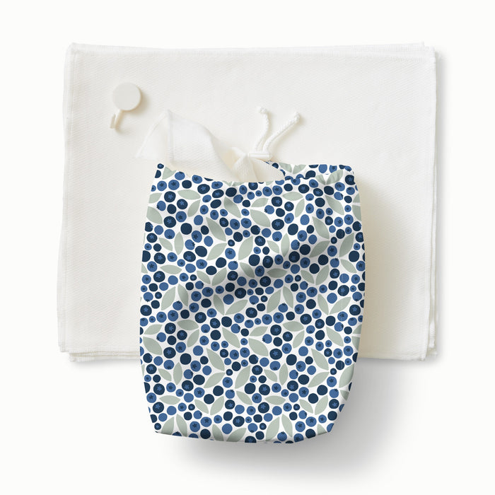 A stack of paperless towels with a ditty bag in Blueberries (a white background with dark navy blue and light blue blueberries with light green leaves) with paperless towels coming out the top and a white hook
