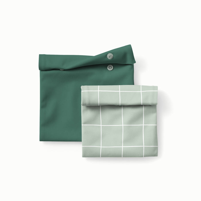 Sandwich size reusable bag in dark green and a snack size reusable bag in Lattice (a light green background with white lined grid pattern)